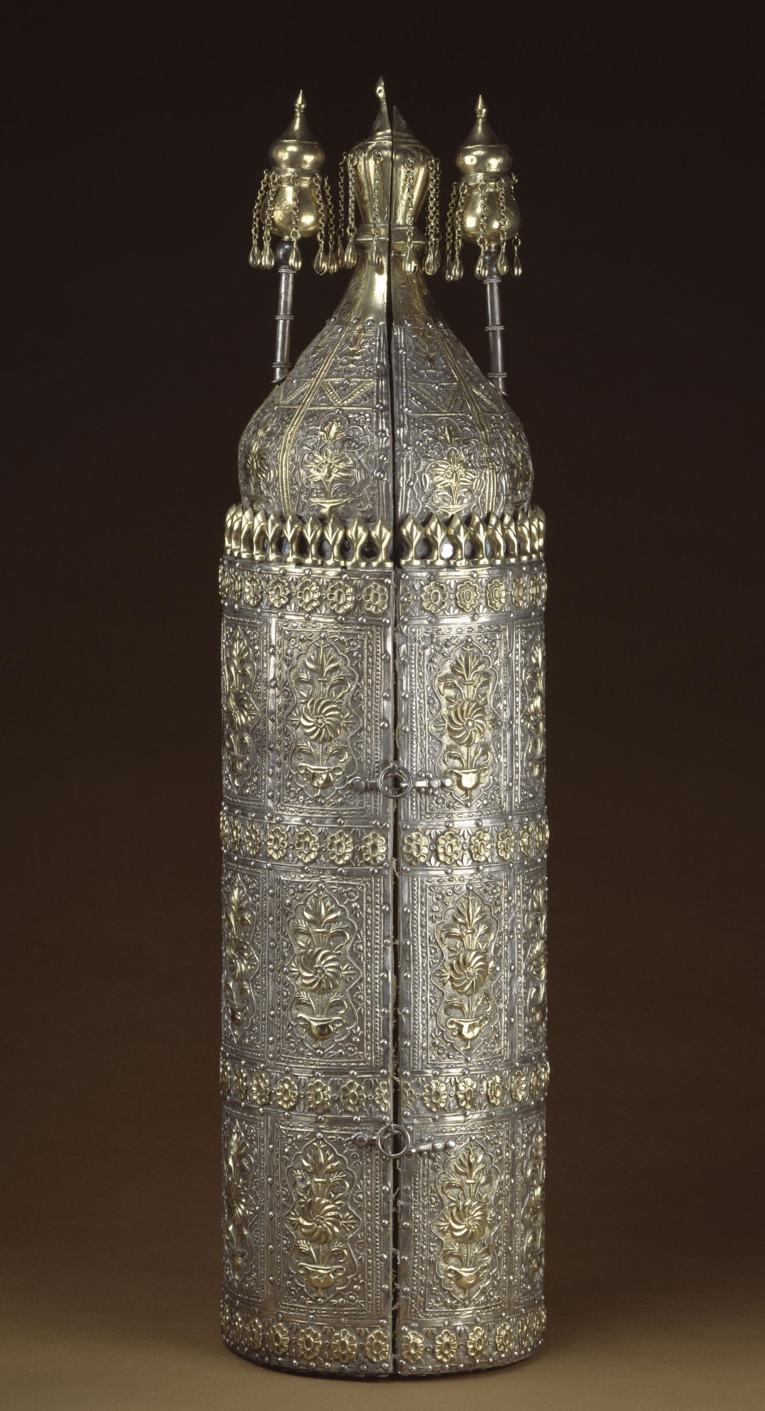 Ornately decorated cylindrical case with Hebrew writing on top and scroll inside; closed cylindrical case with ornate decoration.