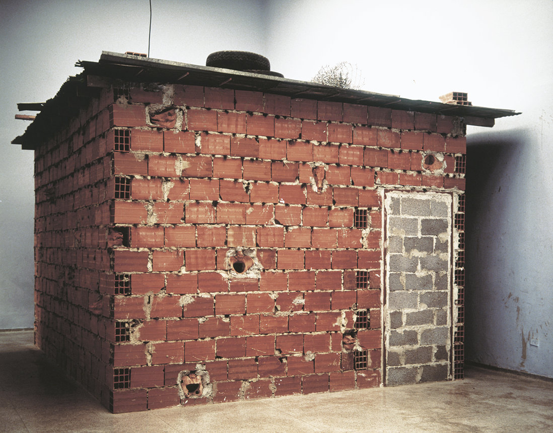 Installation depicting doorless and windowless brick structure. 
