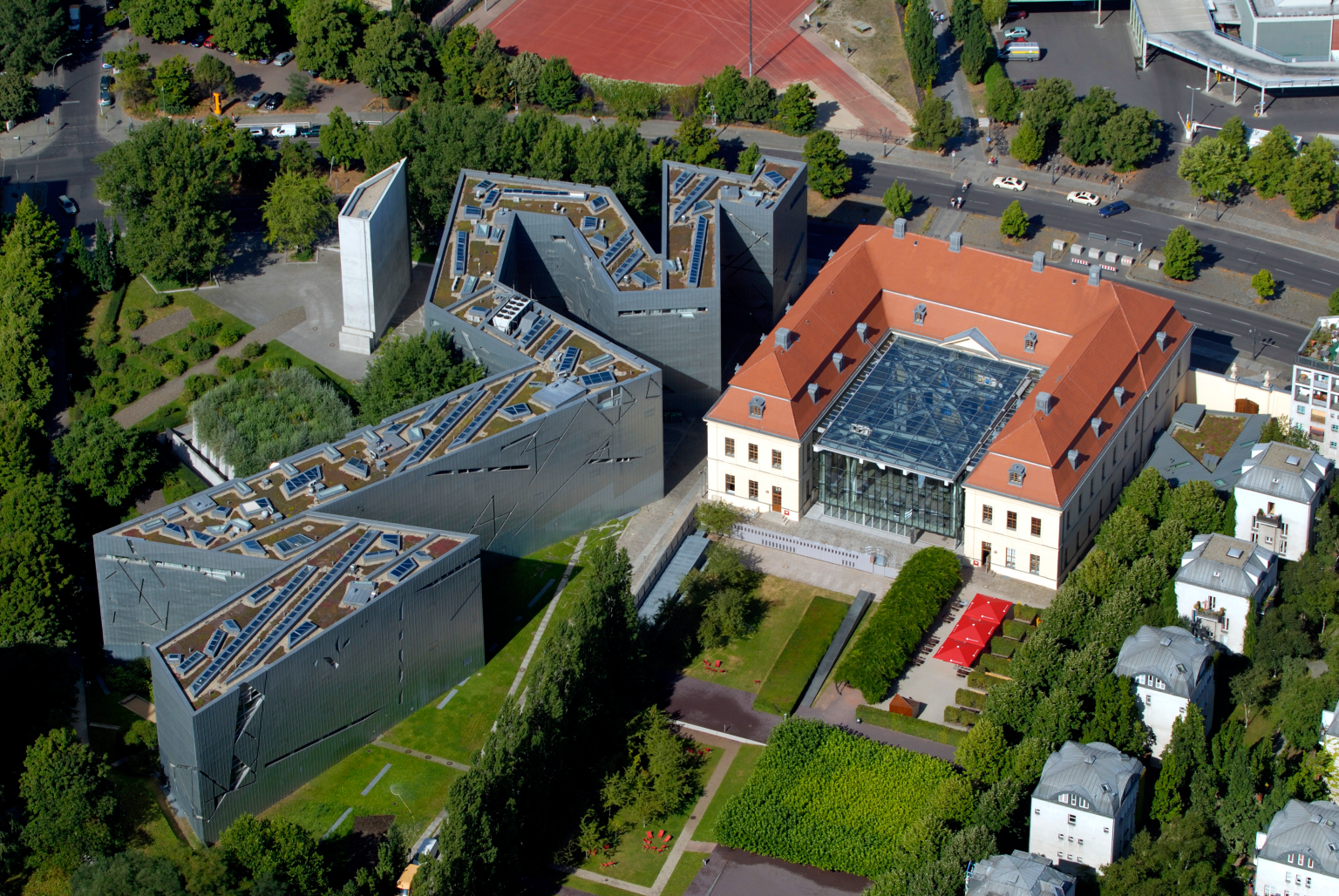 Aerial photograph of angular buildings with trees and grass surrounding. 