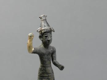 Figurine with horned helmet and raised hand, with gilded bronze on hand and thigh.