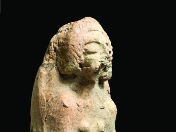 Terra-cotta figurine of pregnant woman cradling belly.