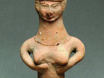 Terra-cotta pillar figurine of woman smiling slightly.