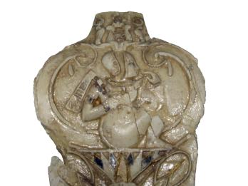 Carved leaf-shaped ivory relief of child sitting on a lotus flower.