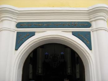 Photograph of arched entrance to building with Hebrew over lintel. 