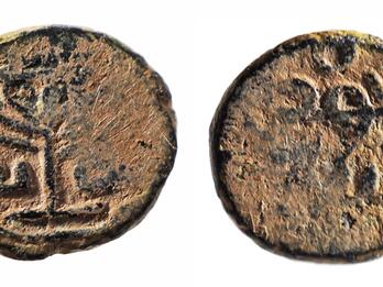Photo of two sides of an ancient coin, featuring a seven-branched candelabrum and Hebrew lettering.