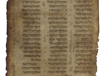 Worn manuscript page with three columns of Hebrew text, with annotations along the edges and between the columns.