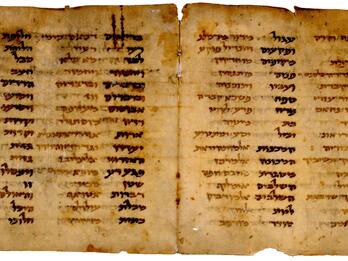 Facing pages of a worn, handwritten book in Hebrew script, each with two columns of words in black next to phrases in brown.