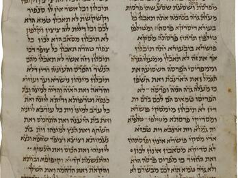 Worn page with two columns of writing in Hebrew script.