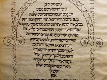 Hebrew manuscript page with micrography in the shape of an ornate arch around the central text, which is written in the shape of a bell or lantern.
