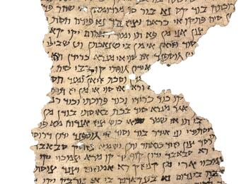 Irregular, torn fragment of parchment filled with vowelless Hebrew writing.