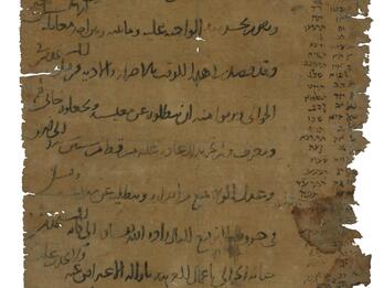 Frayed vertical parchment mainly filled with Arabic script, with smaller denser Hebrew (Ladino) script in the margins, consisting of two columns of words in the right column and a paragraph at the bottom.