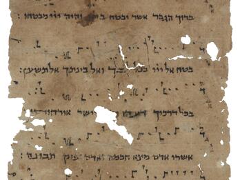 Damaged parchment page of Hebrew script with symbols above and between the lines.