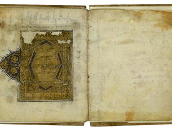 Book open to two facing pages, with a damaged gold geometric and floral pattern with blue and black details.