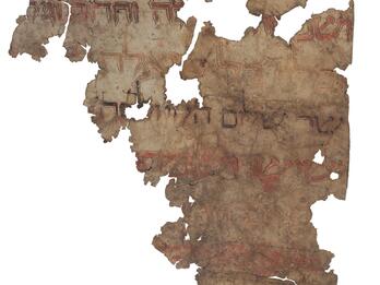 Damaged parchment fragment with faded Hebrew script in gold, red, and black with decorations and contrasting outlines.