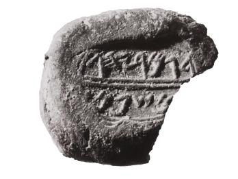 Round clay piece inscribed with Hebrew.