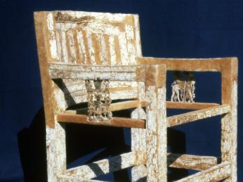 Armed chair decorated with ivory inlay including elaborate carving on arms.