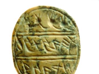 Oval seal decorated with garland and four pomegranates at top and Hebrew inscription.