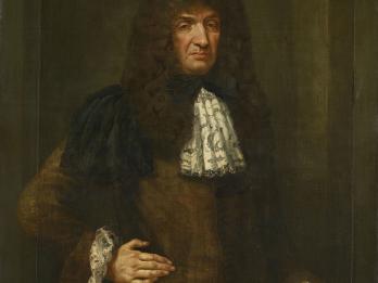 Portrait painting depicting man with long wavy hair standing facing viewer with right hand on hip, dressed in coat with lace cuffs and lace collar.