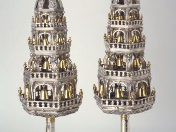 Pair of silver tower-shaped finials with crowns constructed like multitiered towers of arched cutouts decorated with bells. 