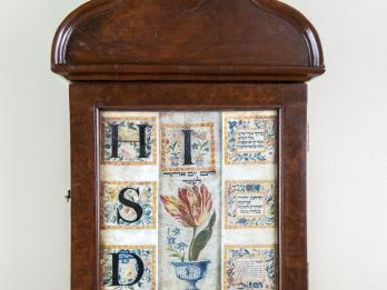 Wood wall piece with bold Hebrew letters and flowers