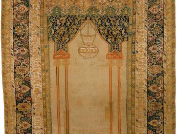 Textile with woven image of two hands at bottom beneath censer and decorative borders. 