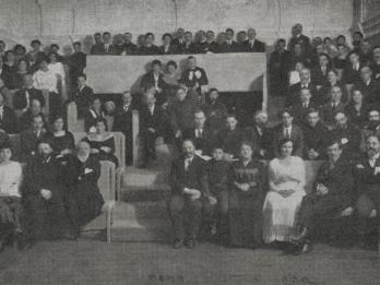 Photograph of many people sitting in rows.