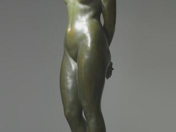 Sculpture of nude woman looking down.