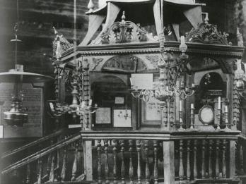 Photograph of platform with short staircase, conical roof, and elaborate pendant lamps.