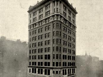 Photograph of tall building with many symmetrical windows.