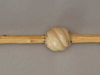 Ivory pointer in shape of hand on one end with three ivory and brass beads.
