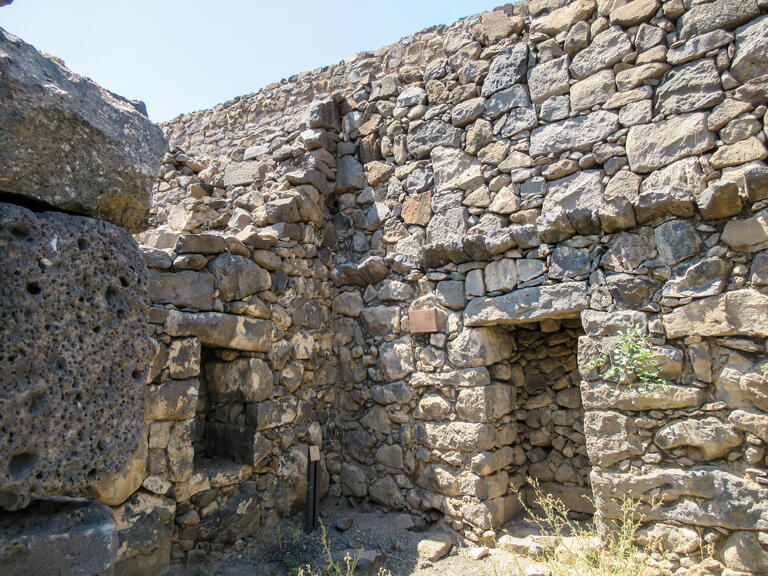 Two stone walls with niches meeting at a corner.