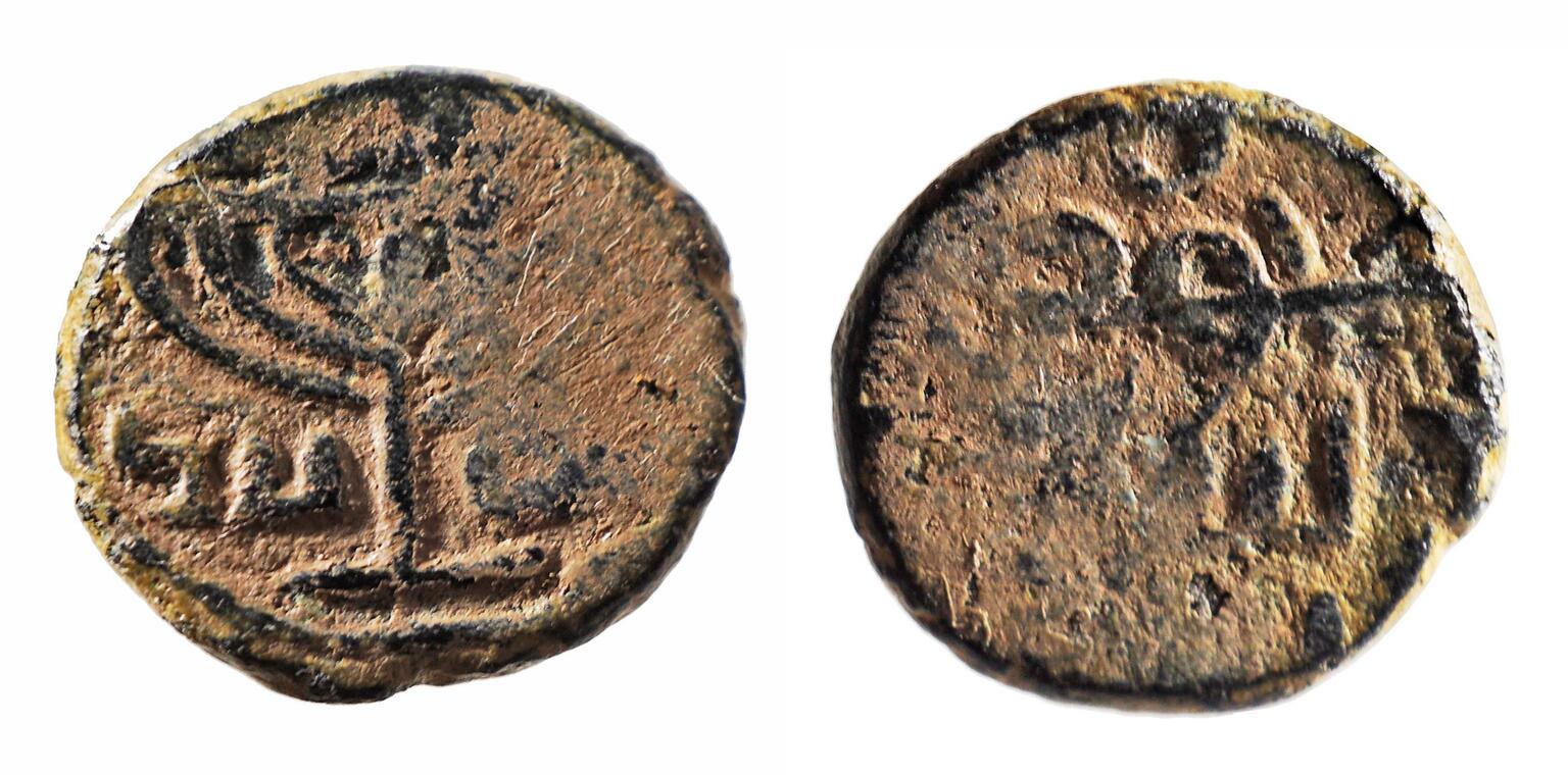 Photo of two sides of an ancient coin, featuring a seven-branched candelabrum and Hebrew lettering.