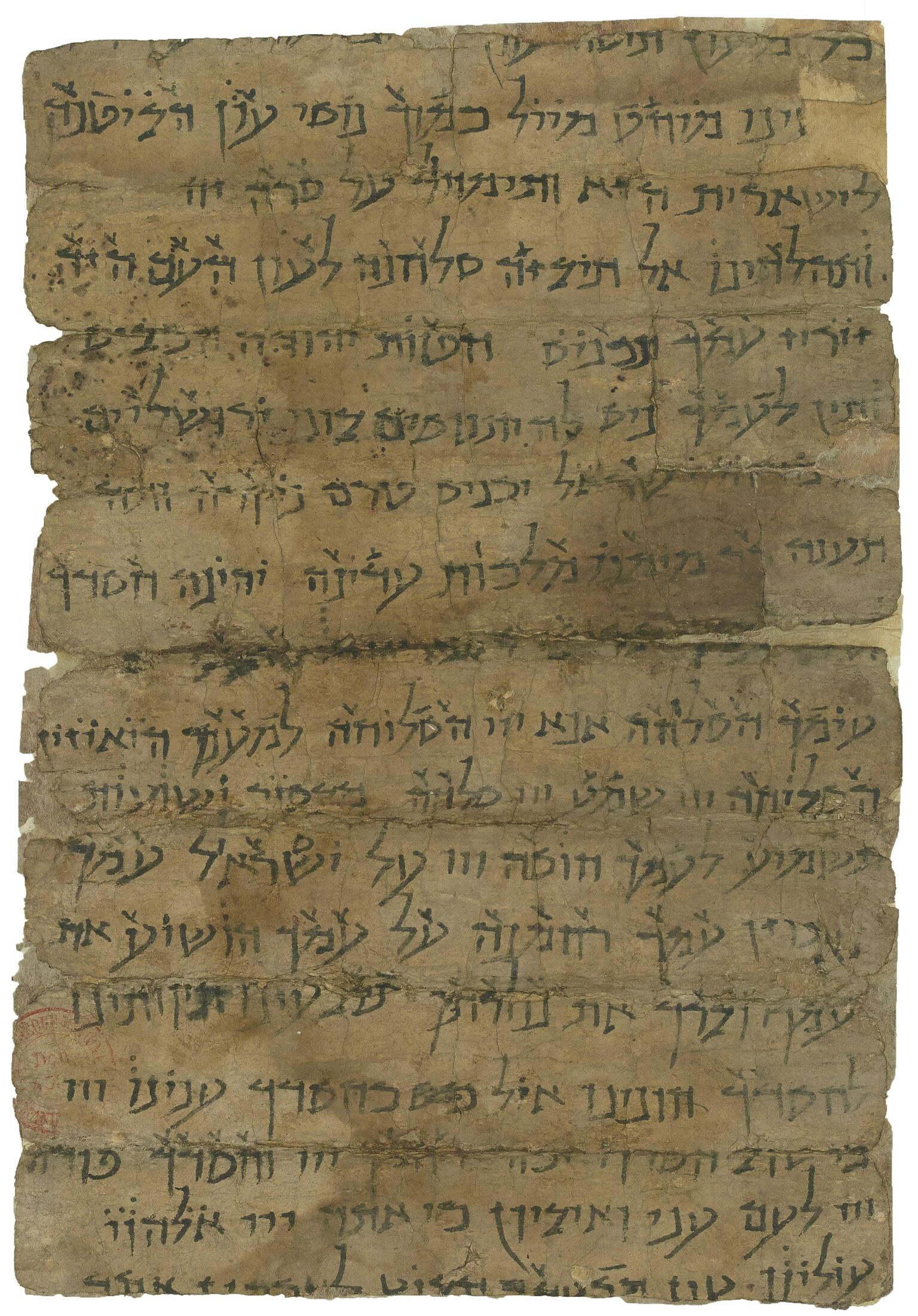 Damaged, stained parchment filled with Hebrew writing with markings above.