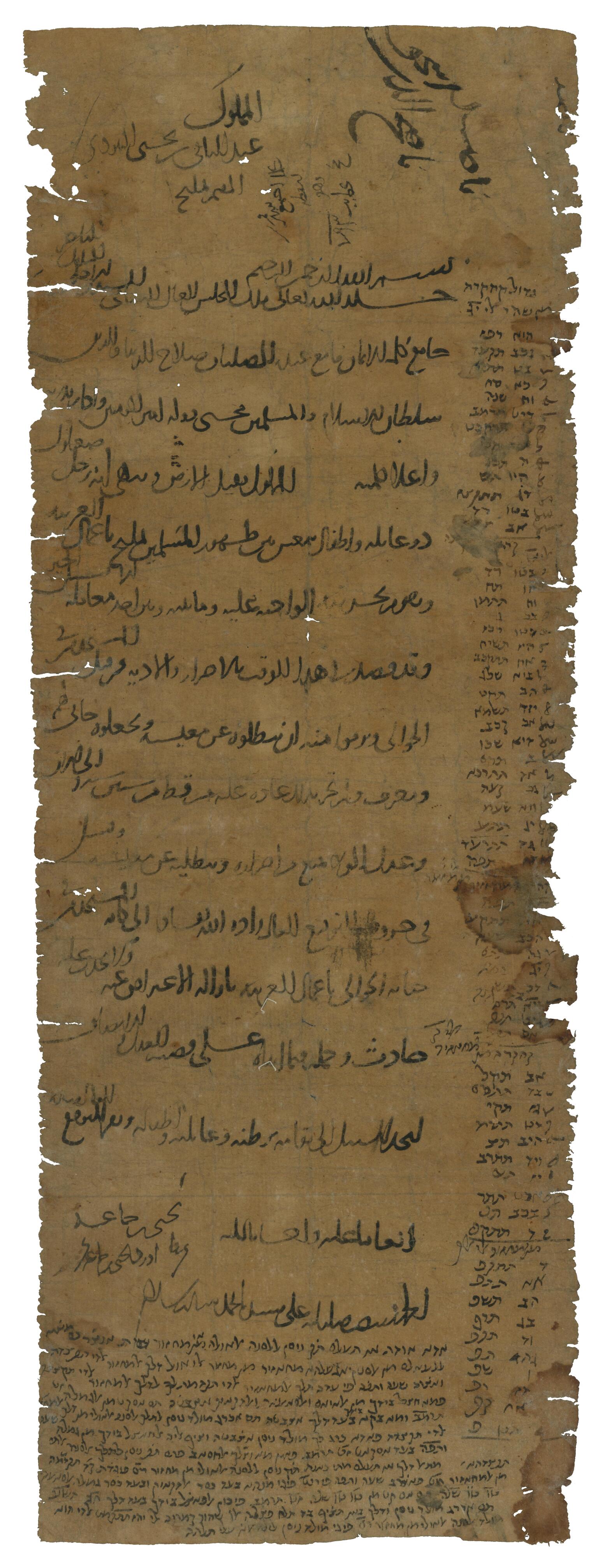 Frayed vertical parchment mainly filled with Arabic script, with smaller denser Hebrew (Ladino) script in the margins, consisting of two columns of words in the right column and a paragraph at the bottom.