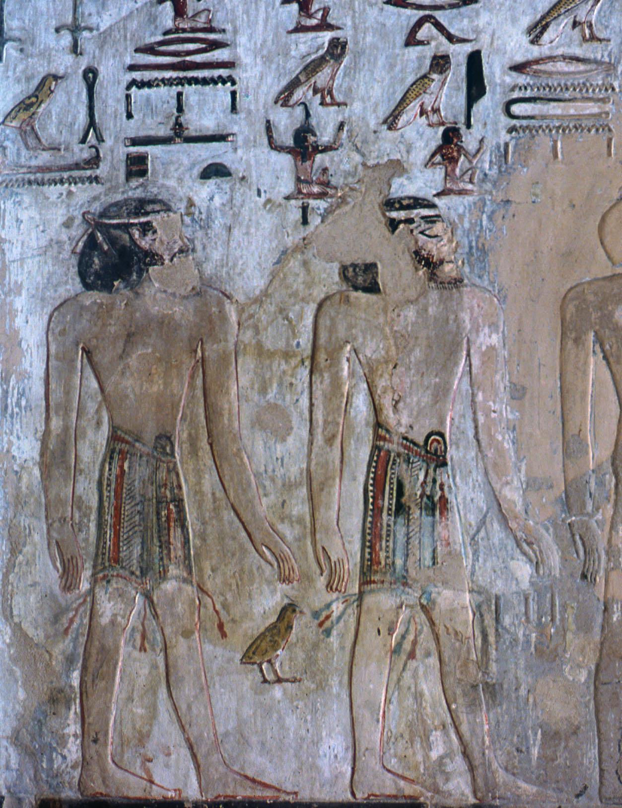 Mural of two figures looking at each other under hieroglyphs.
