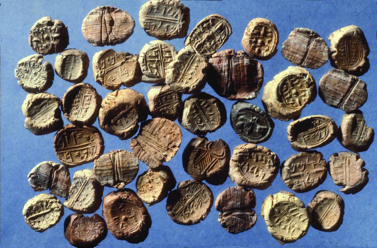 40 clay seals showing impressions of images or alphabetic inscriptions.
