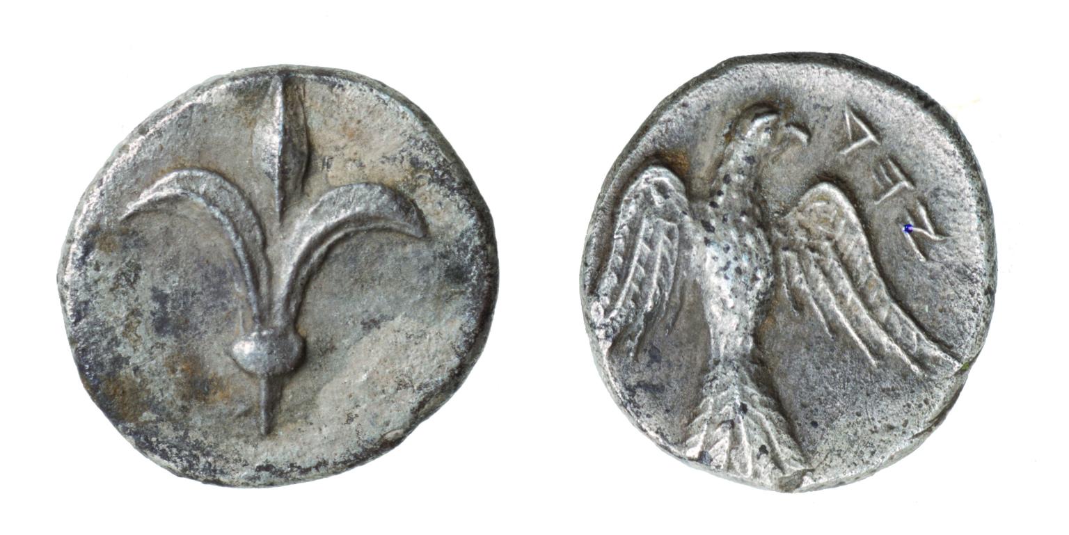 Front and back of coin, with lily on one side and falcon on the other