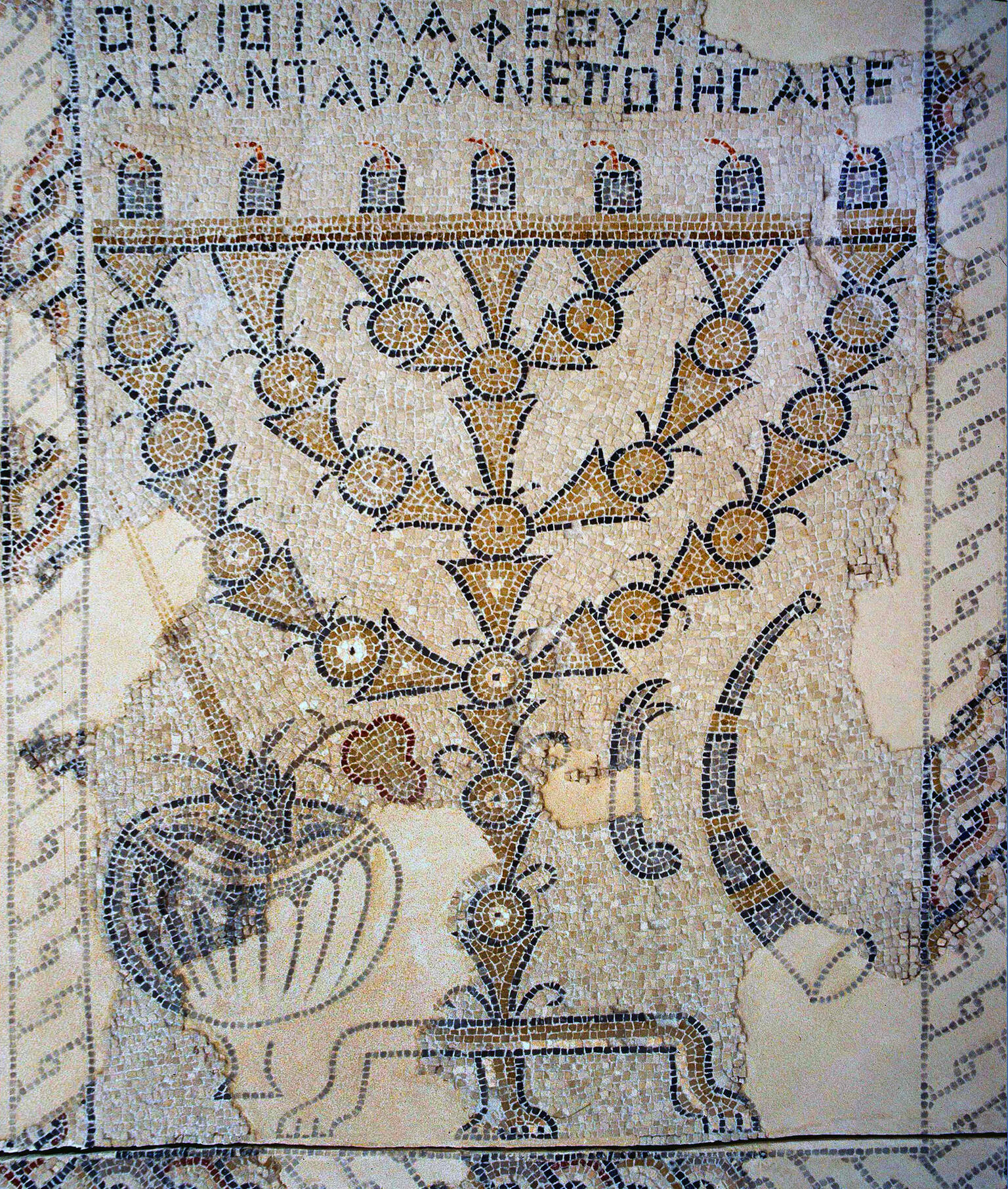 Ancient mosaic showing a large menorah with curved branches, flanked by ritual objects, including a shofar and bowl, with Greek inscriptions above and a decorative border.