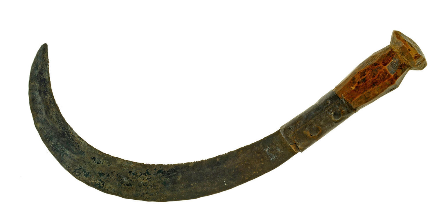 A curved, rusted sickle with a metal blade and a worn handle.
