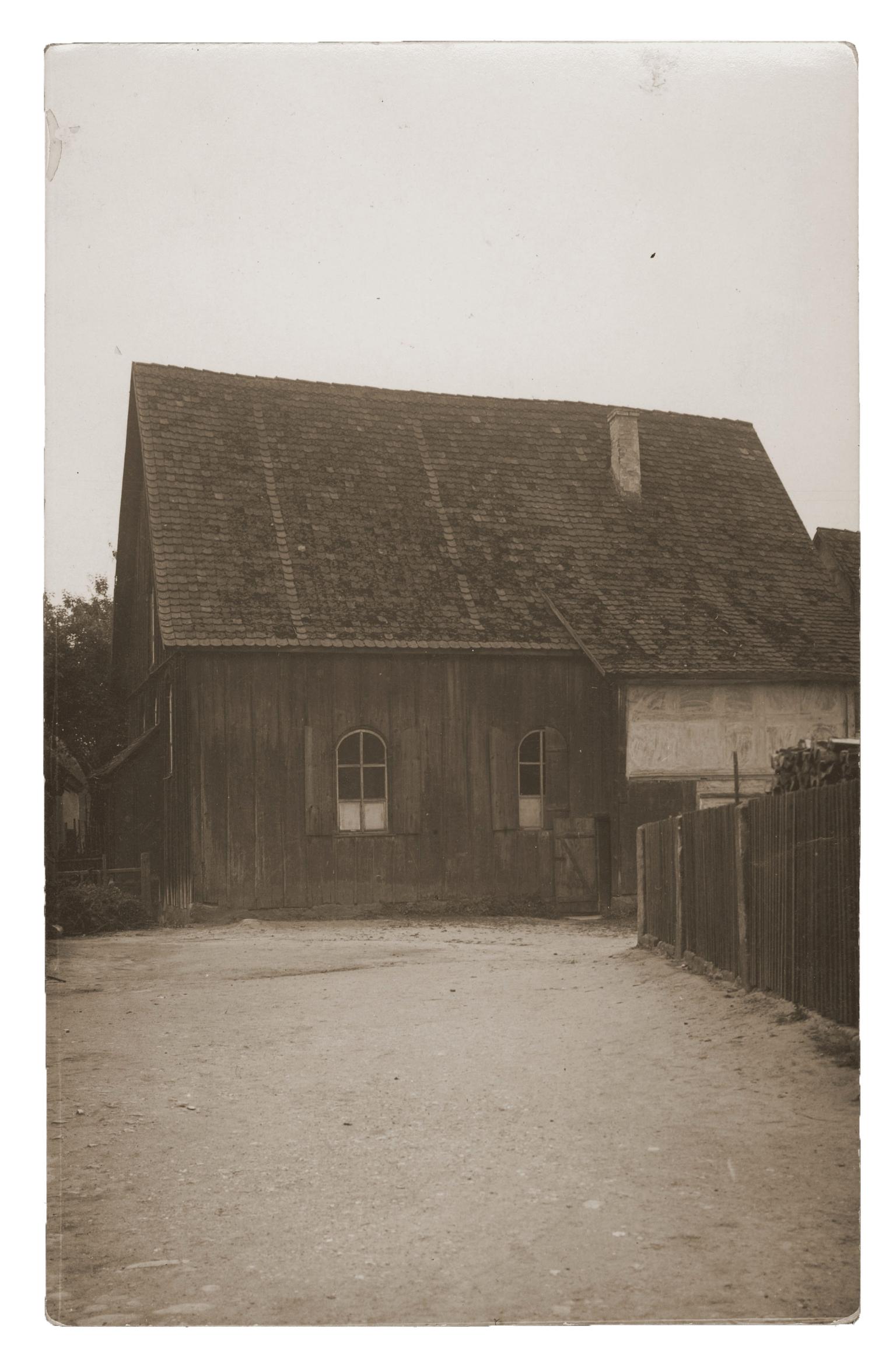 Exterior view of wooden building with dirt path.
