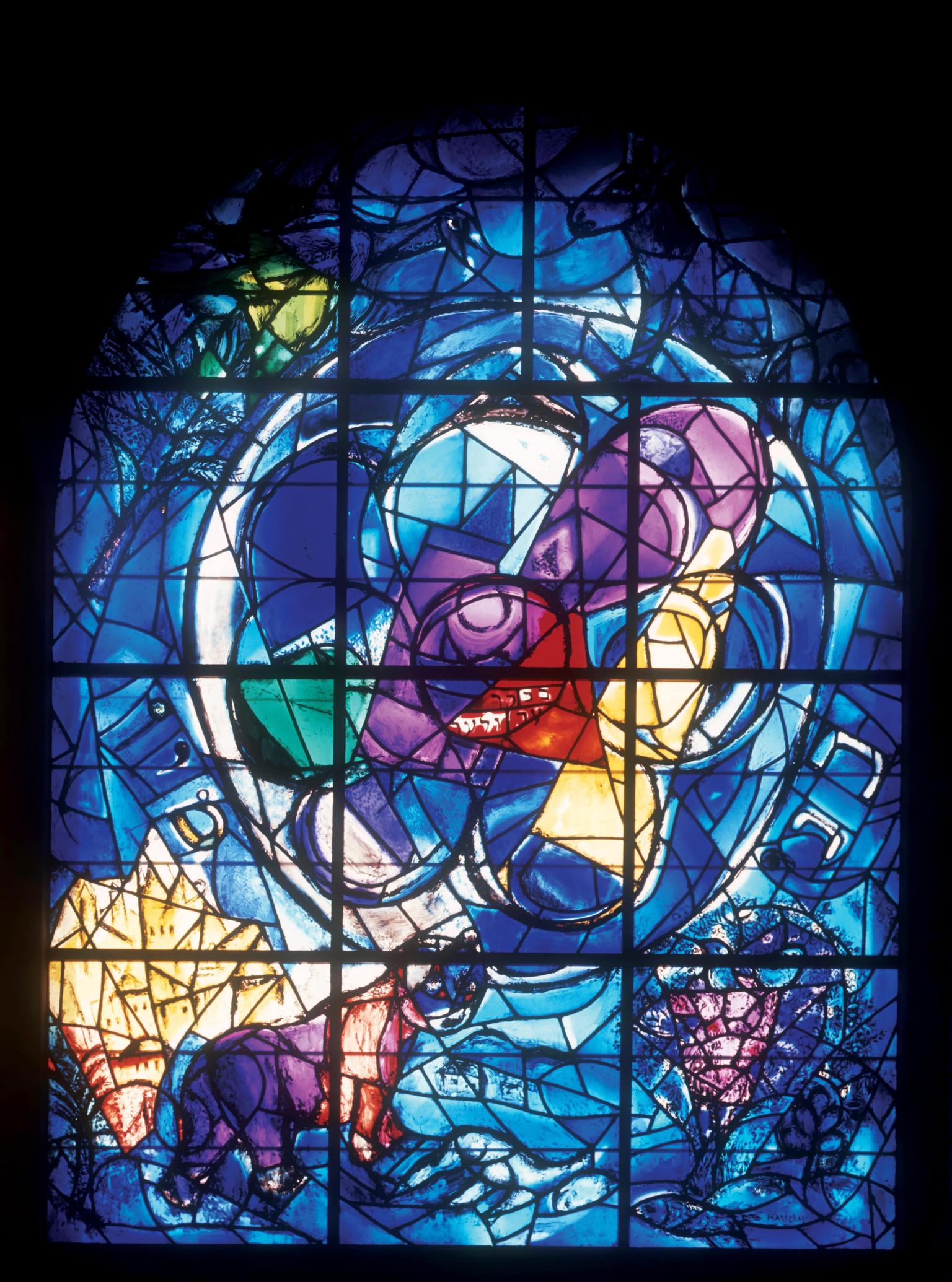 Stained glass window featuring large circle in center and a wolf in bottom right corner devouring prey.