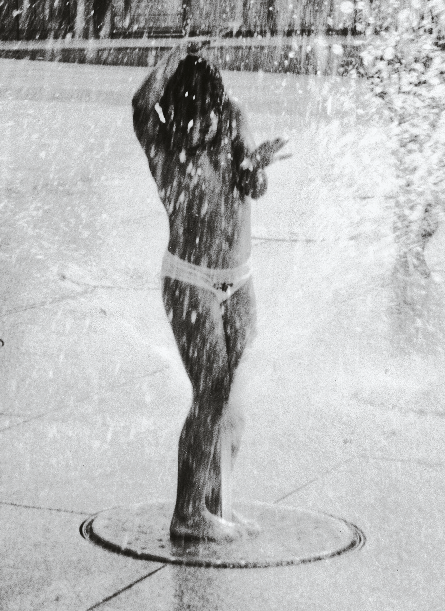 Photograph of child playing in fountain.