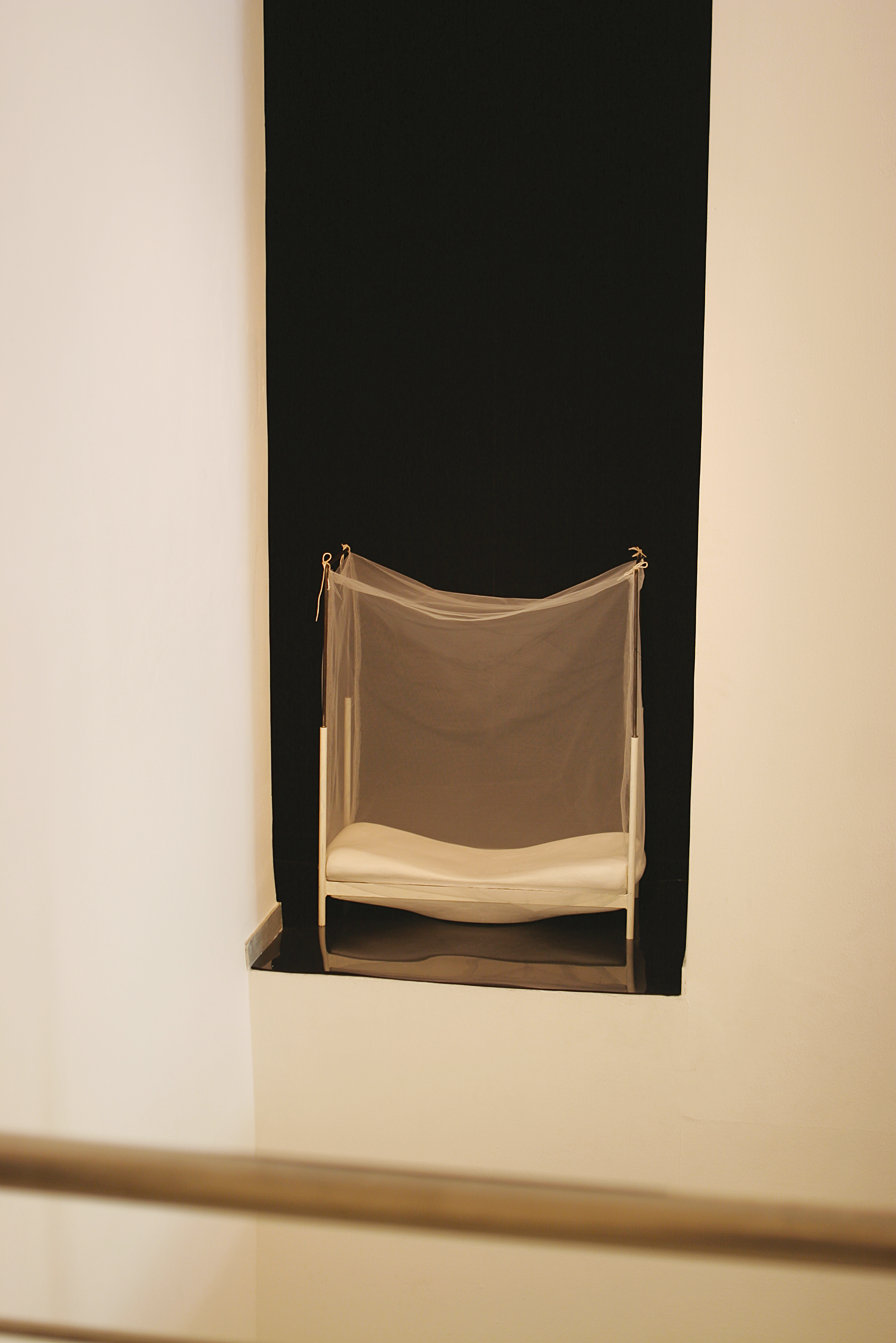 Installation depicting a wall inset with bed inside.