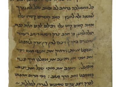 Worn parchment page with Hebrew script in black ink with brown vowels and other markings.
