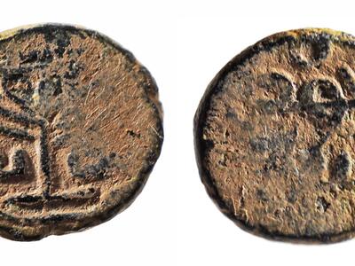 Photo of two sides of an ancient coin, featuring a seven-branched candelabrum and Hebrew lettering.