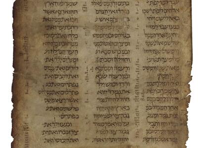 Worn manuscript page with three columns of Hebrew text, with annotations along the edges and between the columns.