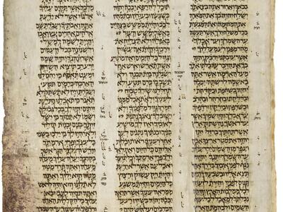 Manuscript page with three columns of Hebrew text, with smaller writing in the margins and between columns.