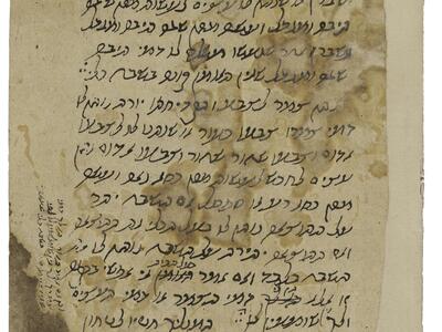 Stained manuscript with Hebrew text and smaller notes in the margin and at the top corner.