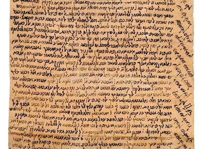 Damaged, long parchment densely filled with vowelless Hebrew writing, including diagonal lines filling the top and right margins.
