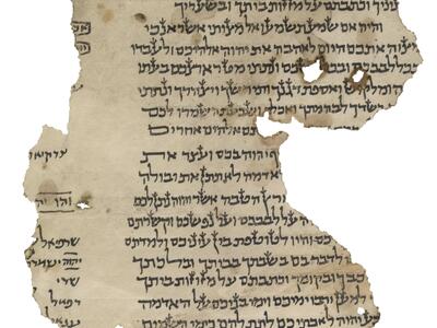 Damaged, irregular manuscript fragment with paragraphs of vowelless Hebrew script, obscured by a torn edge, and, at the other torn edge, a glimpse of a small six-pointed star and more script, some of which is underlined or boxed.